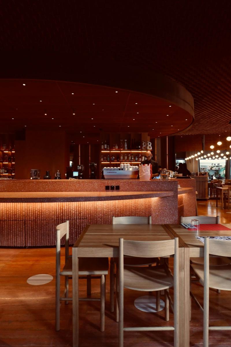 A warmly lit restaurant room with tables and a bar