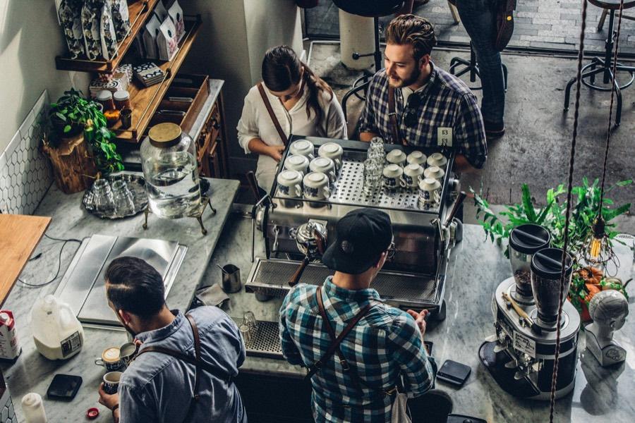Baristas making drinks behind a café counter