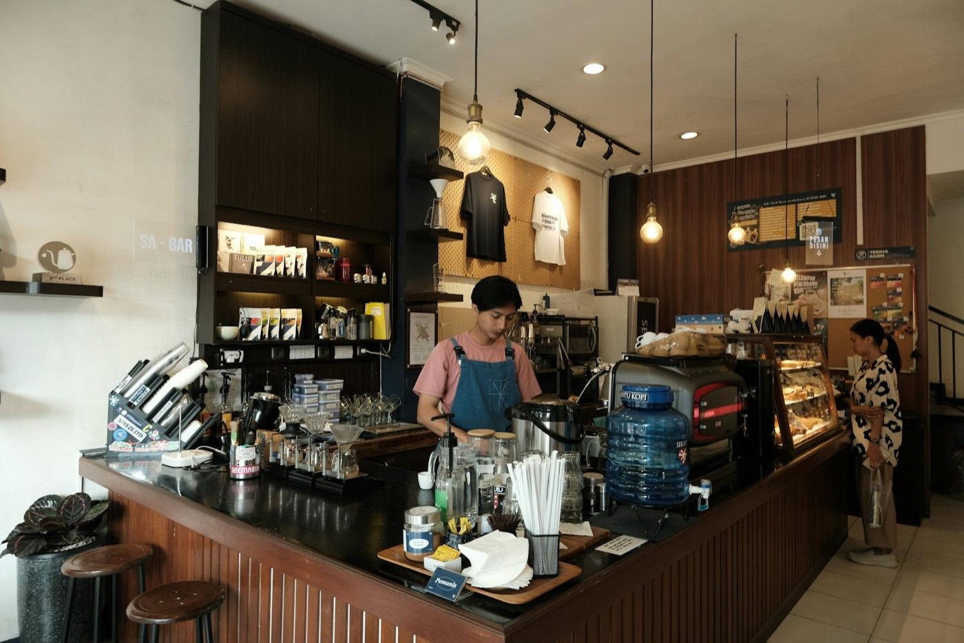 A barista at work behind a bright café counter